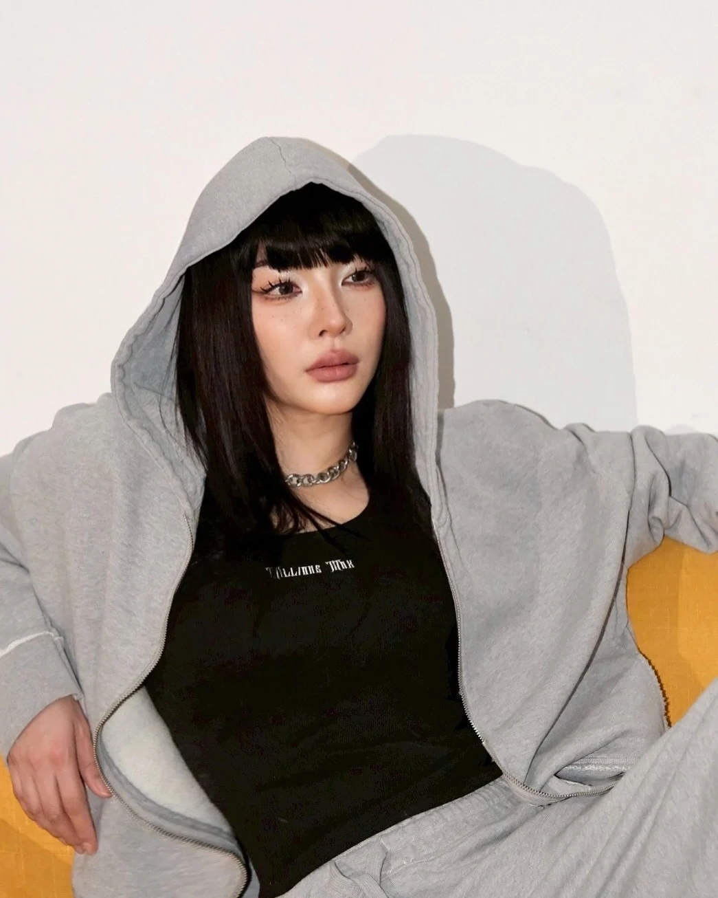Faye Peraya wearing a black Millions Max T-shirt with a grey hoodie